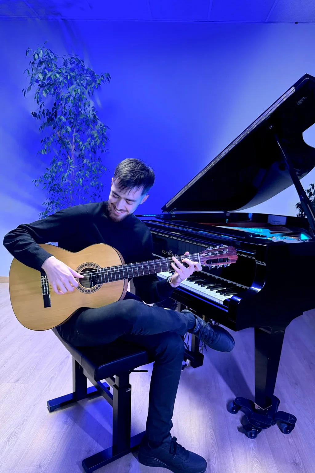 Profesor tocando la guitarra clásica en un aula luminosa