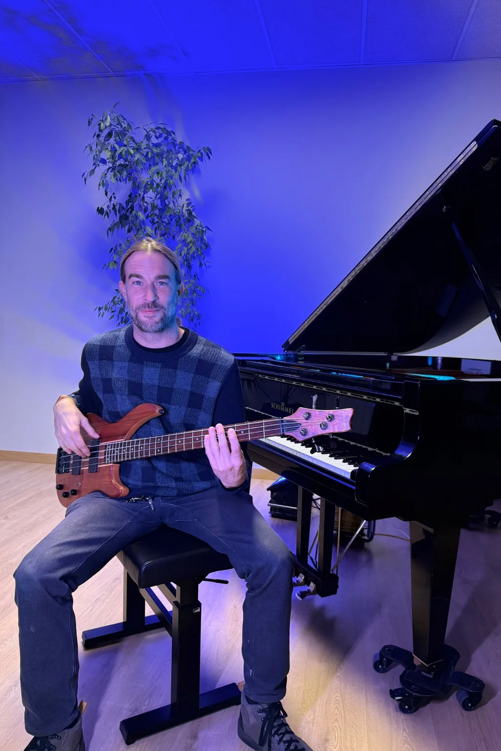 Profesor tocando guitarra eléctrica en una sala de ensayo