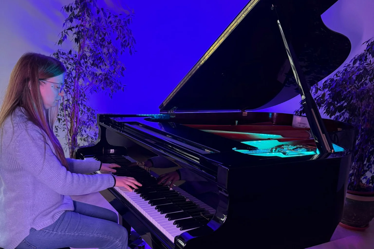 Piano vertical junto a una ventana en un aula de música