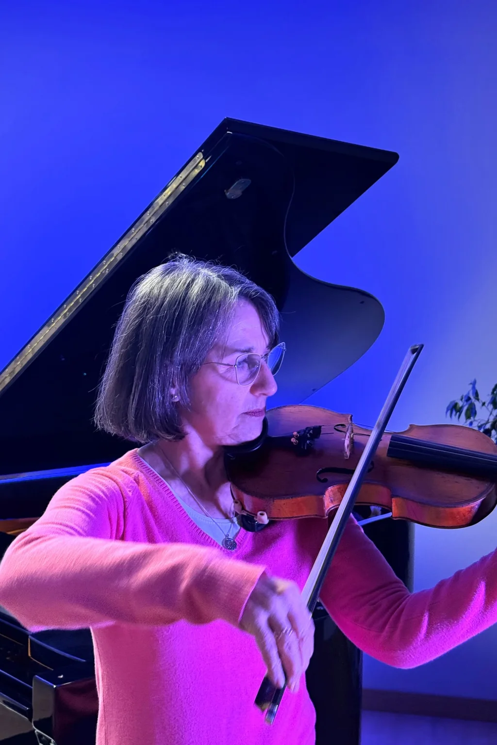 Profesor de violín tocando en un aula con luz natural
